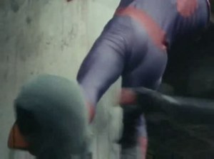 Still attached to the side of a building, Spider-Man kicks a Ninder in the face.